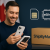 American shopper holding a new iPhone with Canadian flag and ShipByMail parcel box in background, representing cross-border iPhone shopping.