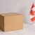 Cardboard box beside a small Canadian flag on a marble surface